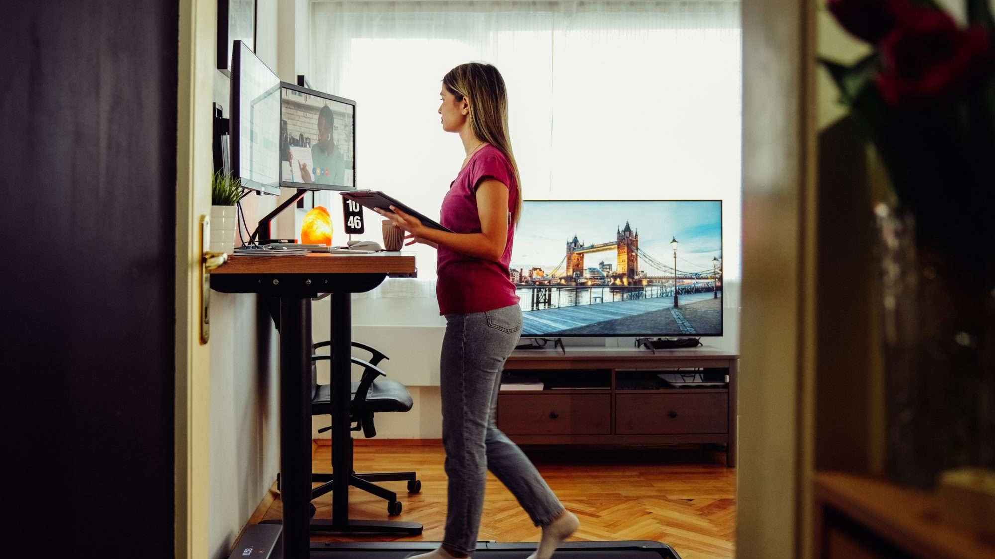 Person using walking pad at standing desk while working from home